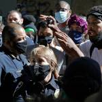 A protester who did not give his name talks with Seattle Police assistant chiefs Adrian Diaz (left) and Deanna Nollette Thursday inside what is being called the Capitol Hill Autonomous Zone in Seattle.(AP Photo/Ted S. Warren)