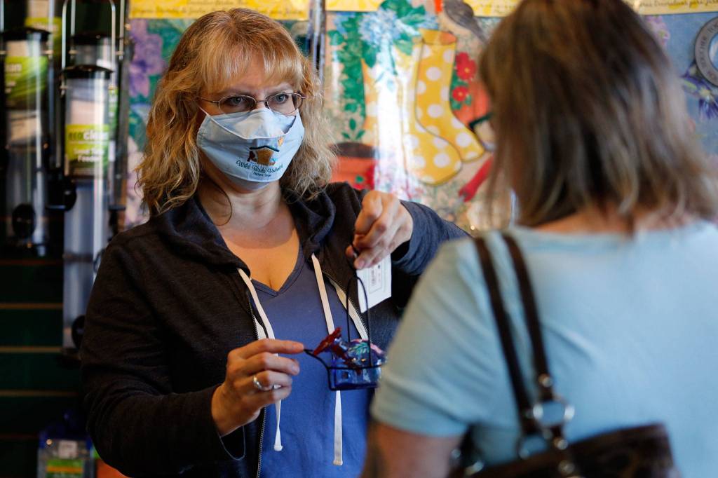 Jenny Blase, manager, helps a customer Thursday afternoon at Wild Birds Unlimited in Everett. (Kevin Clark / The Herald)