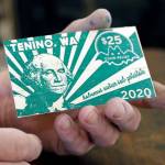In this May 21 photo, Loren Ackerman holds a piece of wooden money he printed on an 1890s-era press in Tenino. (AP Photo/Ted S. Warren)
