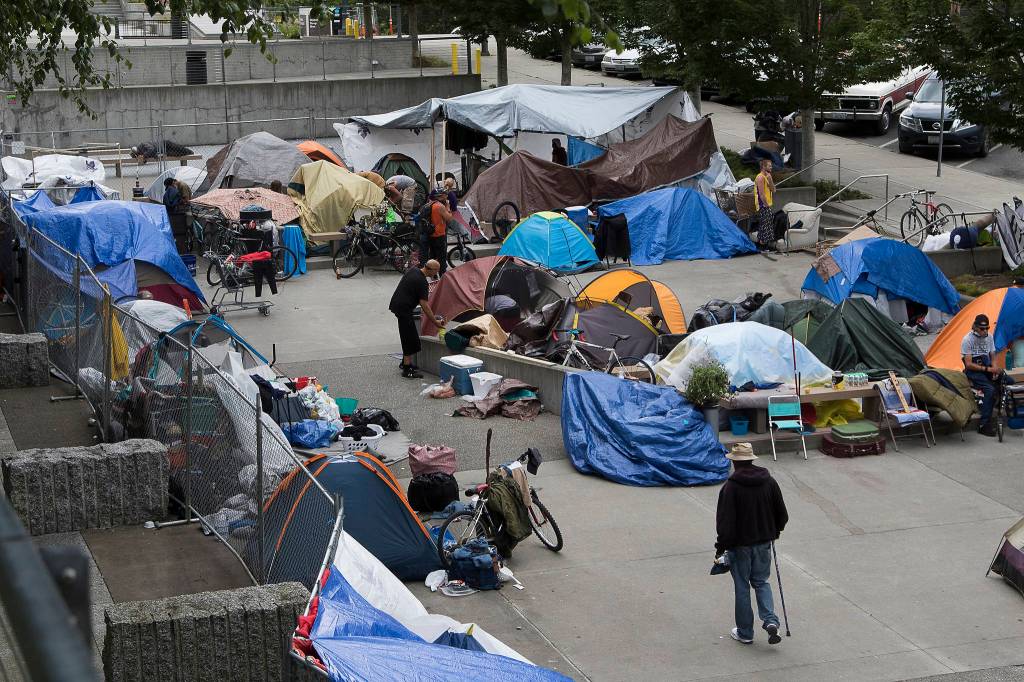 Residents of an encampment for the homeless go about their day at Wall Street and Oakes Avenue in Everett. (Andy Bronson / The Herald)