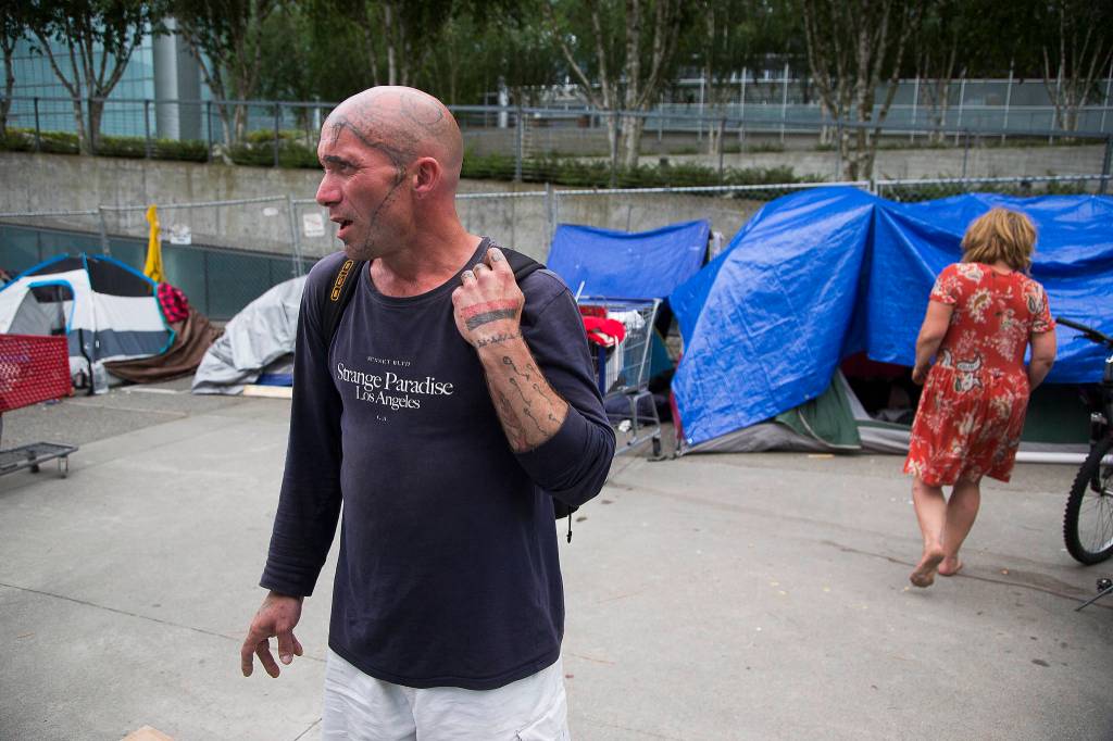 In an encampment for the homeless, Raido Starcloud talks about life on the plaza at Wall Street and Oakes Avenue in Everett. (Andy Bronson / The Herald)