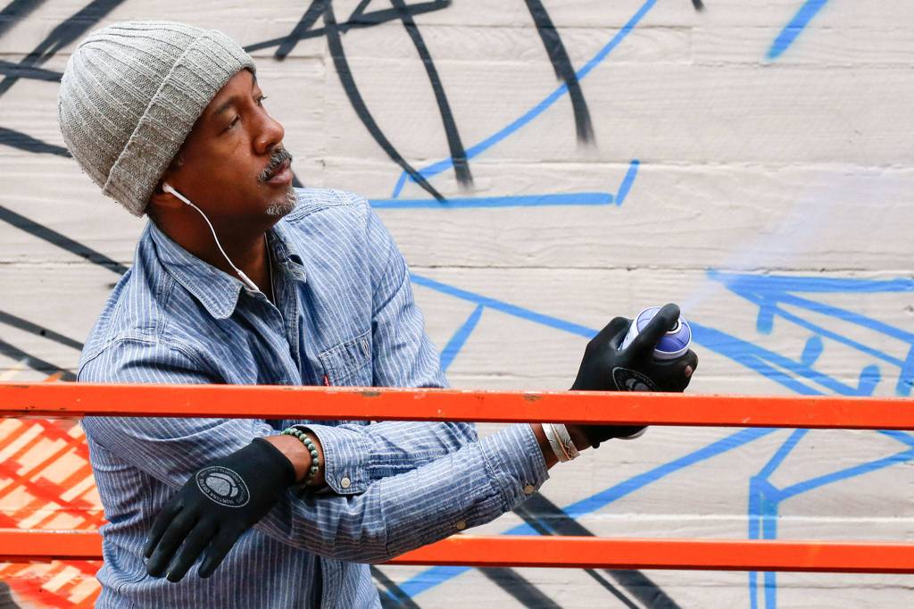 Apexer tests a spray paint can. Graffiti artists use pseudonyms to protect their identities. (Kevin Clark / The Herald)