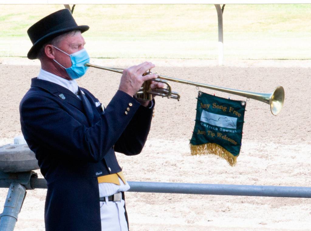 Through his facemask, track trumpeter Dan Harrington calls runners to post before the sixth race at Emerald Downs in Auburn on June 24, 2020. (Doug Parry photo)
