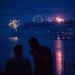 A couple watches people set off fireworks from Priest Point at Legion Memorial Park on July 4, 2018, in Everett. (Olivia Vanni / Herald file)