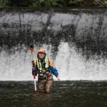 With the Pilchuck Dam behind her, Katie Seguin of the U.S. Geological Survey holds a prism pole while standing in the Pilchuck River on Tuesday in Granite Falls. Crews were mapping the riverbed to track how sediment will move once the dam is removed. (Andy Bronson / The Herald)