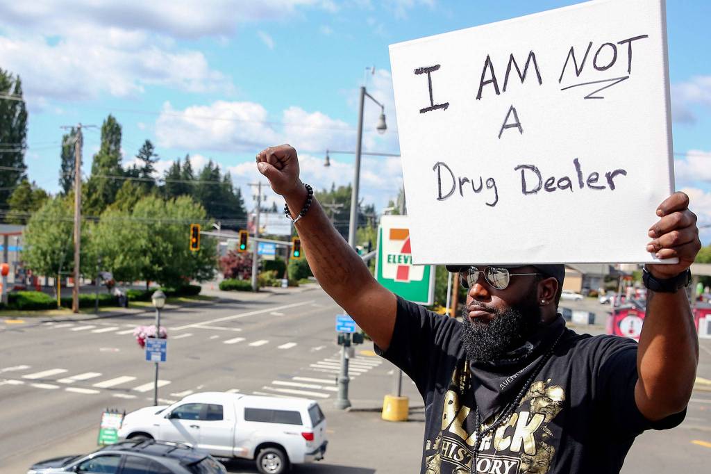 Elton Davis salutes on a rooftop as part of a weekly protest. Hes been charged with a misdemeanor for noise and public nuisance. (Kevin Clark / The Herald)