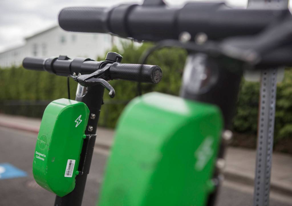 A pair of Lime scooters are seen in front of Pop Keeney Stadium on Wednesday in Bothell. (Olivia Vanni / The Herald)