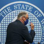 Washington Gov. Jay Inslee signs thank you to one of his sign language interpreters as he wears a face mask after finishing a news conference June 23 at the Capitol in Olympia. (AP Photo/Ted S. Warren file)