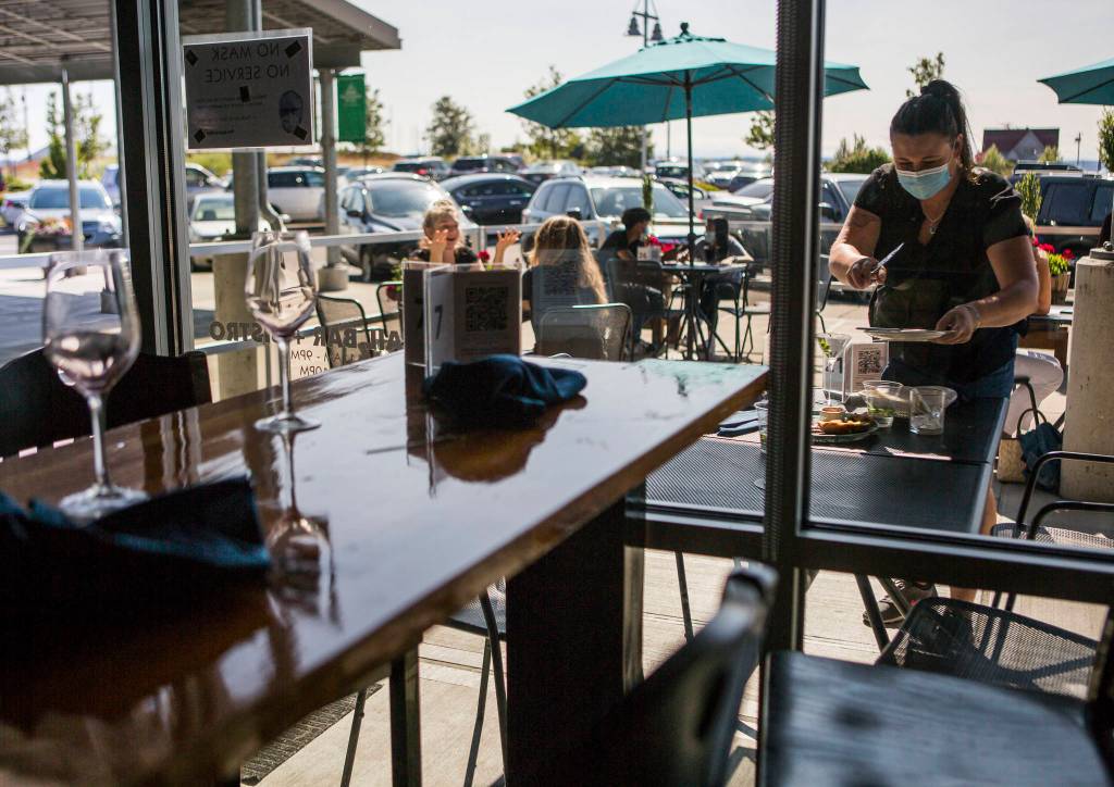 Madison Bauer, who has worked for Bluewater for more than 3 years, busses a table Friday in Everett. (Olivia Vanni / The Herald)