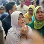 In this Oct. 29, 2018 photo, a relative prays as she and others wait for news on a Lion Air plane that crashed off Java Island at Depati Amir Airport in Pangkal Pinang, Indonesia. (AP Photo/Hadi Sutrisno, File)