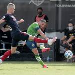 Seattle Sounders midfielder Nicolas Lodeiro (right) takes a shot on goal as Chicago Fire midfielder Fabian Herbers tries to block the shot during the first half Tuesday in Kissimmee, Florida. (Associated Press)