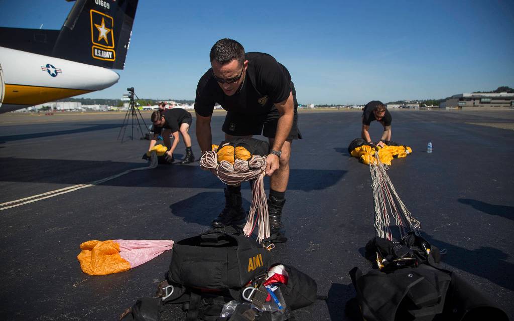Ryan Reis, of Tacoma, packs his parachute as the U.S. Army Golden gets ready to drop into Providence Regional Medical Center in Everett on Tuesday. (Andy Bronson / The Herald)