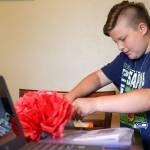 Skyler Jefferson, 10, sorts through his weekly summer science assignments at his home in Marysville. (Kevin Clark / The Herald)