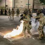 Police respond to protesters during a demonstration Friday in Portland, Oregon. Militarized federal agents deployed by the president to Portland, fired tear gas against protesters again overnight as the citys mayor demanded that the agents be removed and as the states attorney general vowed to seek a restraining order against them. (Dave Killen/The Oregonian via AP)