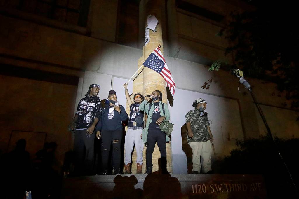 A group of demonstrators addresses the crowd during a Black Lives Matter protest at the Mark O. Hatfield U.S. Courthouse on Thursday in Portland. (AP Photo/Marcio Jose Sanchez)