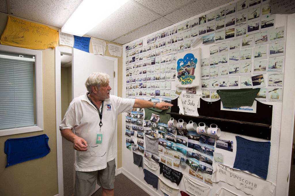 Jim Grant, owner of Northway Aviation at Paine Field in Everett, shows off a room with photos and the shirttails of pilots who have earned their licenses. The business is struggling to operate through the COVID-19 pandemic. (Andy Bronson / The Herald)