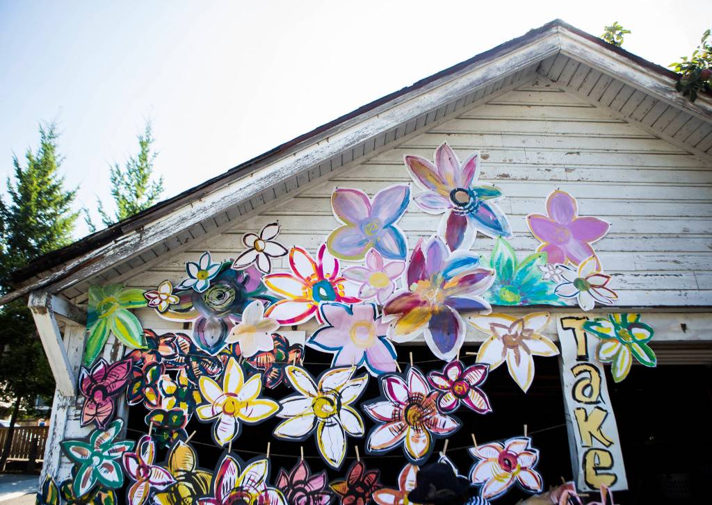 Lennon Wiltbanks flowers adorn the garage of an abandoned and soon-to-be-demolished home in downtown Bothell. (Olivia Vanni / The Herald)