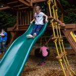 Chelsea Dunning, 5, goes down a slide Thursday while sisters Ella Dunning, 3, and Briana Dunning, 7, play on the swings in Everett. Both Chelsea and Brianna finished the online Early Childhood Education and Assistance Program. (Olivia Vanni / The Herald)