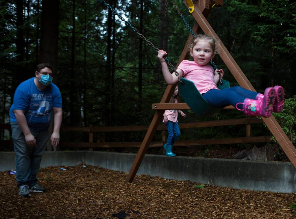 Ella Dunning, 3, is pushed on a swing Thursday by her dad, David Dunning, in Everett. Ella will start the online Early Childhood Education and Assistance Program in a few weeks. (Olivia Vanni / The Herald)