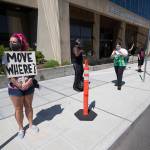 Sabrina Votry stands with a dozen protesters outside the Everett Municipal Building on Wednesday to protest homelessness and sweeping of camps. (Andy Bronson / The Herald)