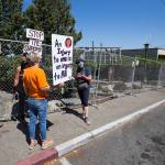 Men put up fencing at Matthew Parsons Park in Everett on Wednesday as protesters talk. (Andy Bronson / The Herald)