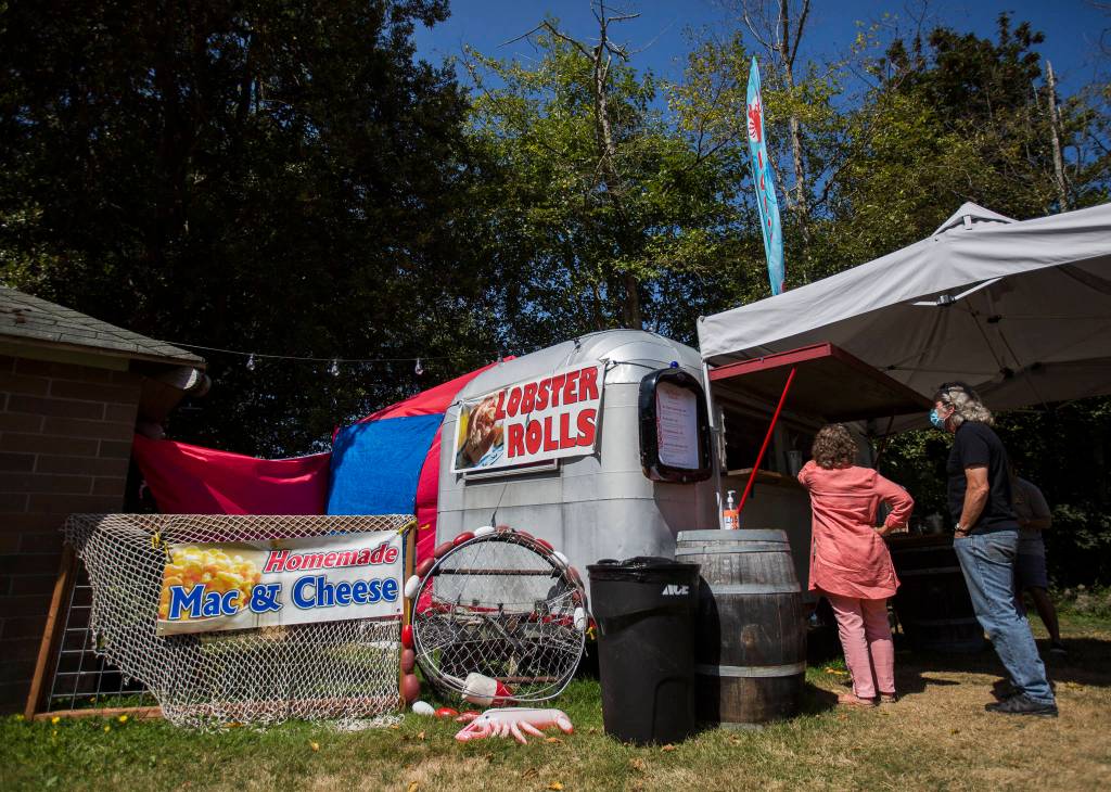 A couple places an order at On The Rock Lobster food truck off Highway 525 in Freeland. (Olivia Vanni / The Herald)