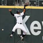 Mariners right fielder Mallex Smith hits the wall as he misses a deep fly ball off the bat of the Rockies Charlie Blackmon for a three-run double during the fifth inning of a game Aug. 8, 2020, in Seattle. (AP Photo/Elaine Thompson)