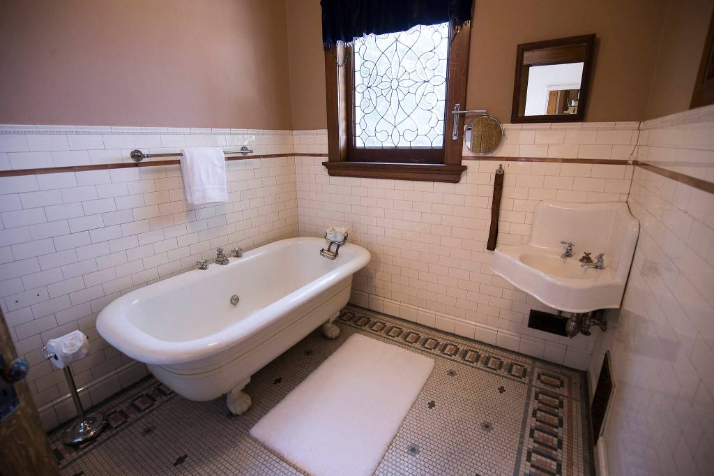 A bathroom sports the original bath, sink and toilet in the basement of the Rucker Mansion. (Andy Bronson / The Herald)