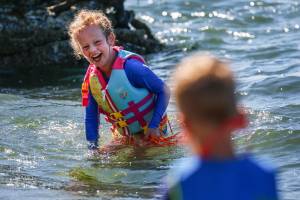 Piper Hounsel, 7, (left) shares a laugh with her brother Weston Hounsel, Friday afternoon in the waters off Howarth Park in Everett on August 14, 2020. (Kevin Clark / The Herald)