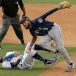 Mariners shortstop J.P. Crawford (right) tags out the Dodgers Chris Taylor, then throws to first to get Max Muncy for a double play during the seventh inning of a game Tuesday in Los Angeles. (AP Photo/Alex Gallardo)