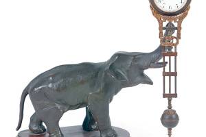 This elephant is swinging the clock, but there doesnt seem to be anything making it move. That is why it is known as a swinger or mystery clock. It is 11 inches tall. (Cowles Syndicate Inc.)