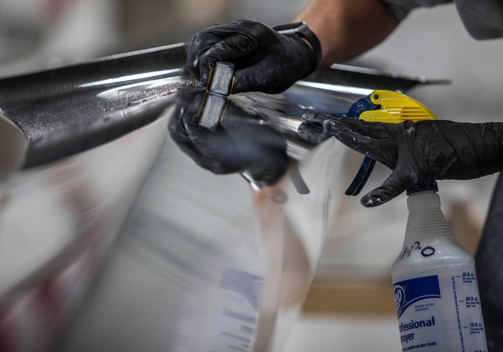An outer shell is sanded and buffed at Pocock Racing Shells in Everett. (Olivia Vanni / The Herald)