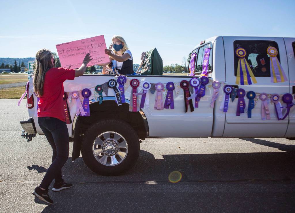Emily Scott accepts a $1,600 donation for the drive-thru Snohomish County Food Drive on Thursday in Monroe. (Olivia Vanni / The Herald)
