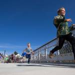 Kids race to see who can cross the Grand Avenue Park Bridge first as it opens for public use Wednesday in Everett. (Andy Bronson / The Herald)