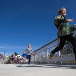 Kids race to see who can cross the Grand Avenue Park Bridge first as it opens for public use Wednesday in Everett. (Andy Bronson / The Herald)