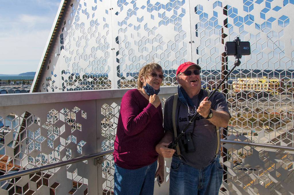 Marianne and Barry McWilliams take a photo together as they walk down the newly opened Grand Avenue Park Bridge on Wednesday in Everett. (Andy Bronson / The Herald)