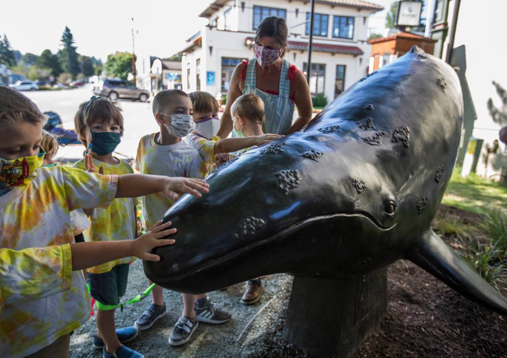 A South Whidbey Childrens Center group admires the new whale sculpture during their walk in Langley. (Olivia Vanni / The Herald)