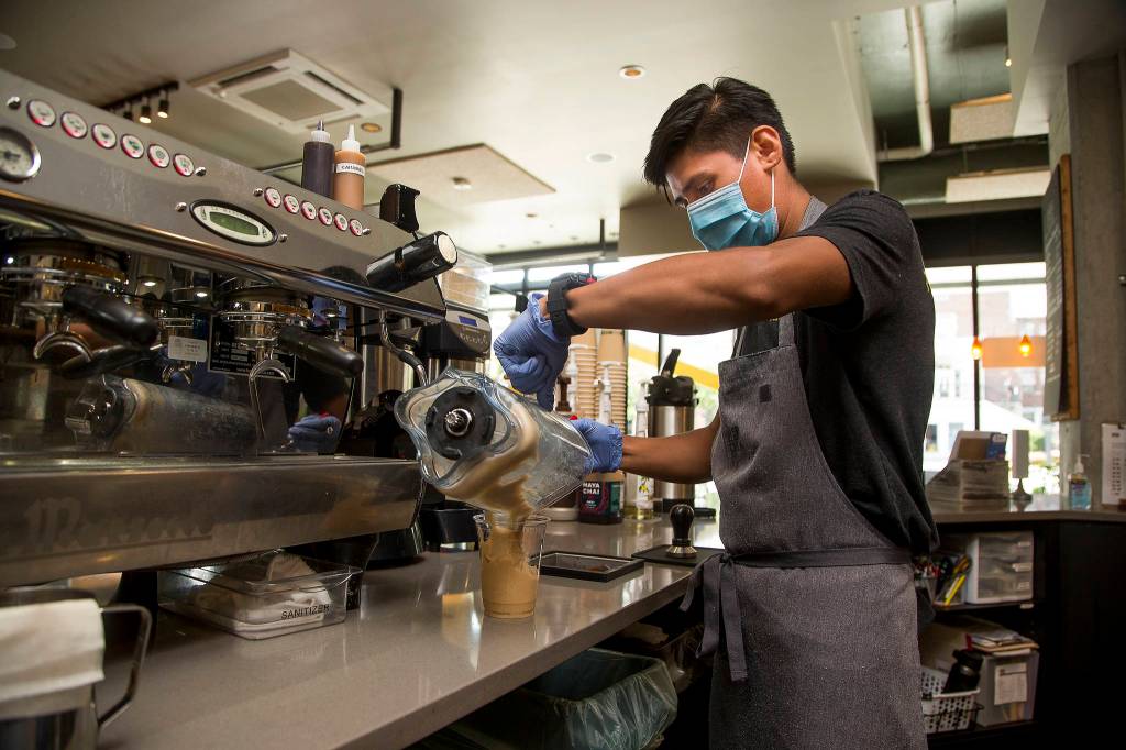 At Kindred Kitchen, on the ground floor of HopeWorks Station in Everett, Josue Malagon pours a drink into a compostable cup. The kitchen uses compostable material for cups and takeout orders. (Andy Bronson / The Herald)
