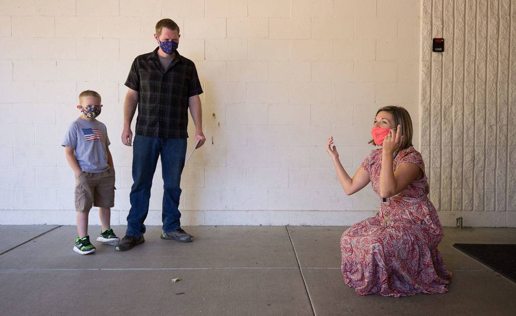 Eagle Creek Elementary principal Bethany Belisle (right) tries to guess new student Seth Waters name during the first day of school in Arlington. (Andy Bronson / The Herald)