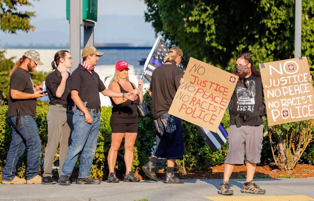 Back the Blue protesters gather with a Black Live Matter protester Friday night at the intersection of Broadway and Pacific Ave in Everett on September 4, 2020. (Kevin Clark / The Herald)