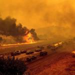 In this Aug. 19 photo, flames from the LNU Lightning Complex fires jump I-80 in Vacaville, California. (AP Photo/Noah Berger, File)