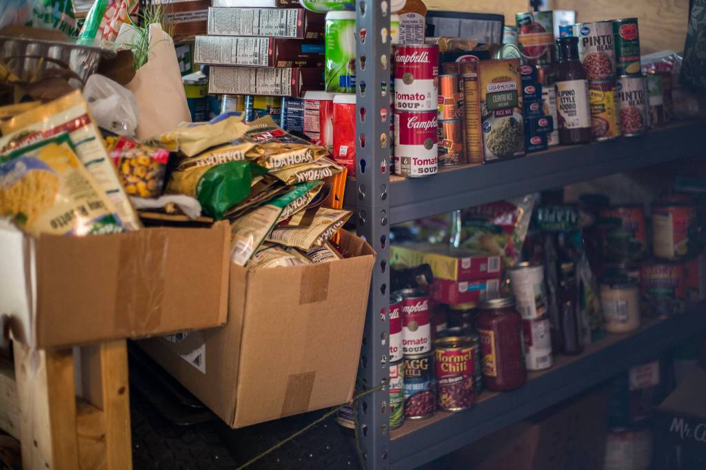 Shelves and boxes of food for donation at Leanne Aleias home in Mill Creek. (Olivia Vanni / The Herald)
