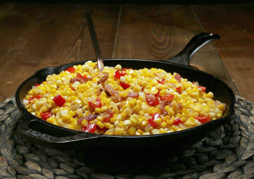 For maque choux, saute chopped onion and bell peppers in fat, then stir in the corn, garlic and bacon. Finish the dish with seasonings and a little cream. (Terrence Antonio James / Chicago Tribune)