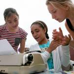 Asianna Smith (center), then 12, of Houston, Texas, attempts to answer the question of the day as Leah Sarles (left), then 11, of Lynnwood, and Hailey Stein, then 11, of Seattle, look on in July of 2014 in downtown Everett. Everetts Word on the Street typewriters werent rolled out this summer and are expected to remain on sabbatical next summer as the city considers cuts to its budget. (Kevin Clark / Herald file photo)