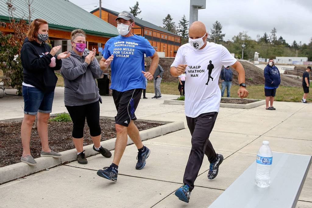 Jim Strickland (left) runs with Tyler Fryberg for the final mile in a 1,000-mile challenge to raise money for Leahs Dream Foundation. (Kevin Clark / The Herald)