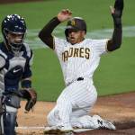 ThePadres Trent Grisham (right) slides as he scores past Mariners catcher Luis Torrens during the third inning of a game Sept. 18, 2020, in San Diego. (AP Photo/Denis Poroy)
