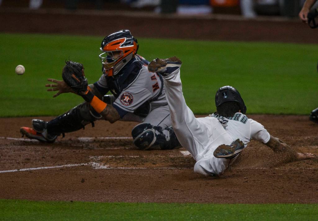 The Mariners J.P. Crawford slides into home plate to score during a game against the Astros on Wednesday, Sept. 23, 2020, in Seattle. (Olivia Vanni / The Herald)