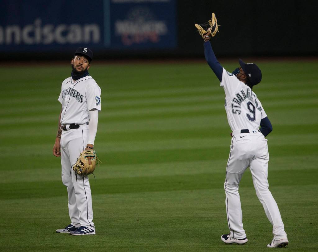 The Mariners J.P. Crawford watches as teammate Dee Strange-Gordon makes a catch during a game against the Astros on Wednesday, Sept. 23, 2020, in Seattle. (Olivia Vanni / The Herald)