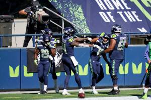 Seattle Seahawks receiver Tyler Lockett, second from right, celebrates with teammates DK Metcalf, center, and Jordan Simmons, right, after Lockett scored a touchdown against the Dallas Cowboys during the first half of Seattles 38-31 victory Sunday at CenturyLink Field. (AP Photo/Elaine Thompson)