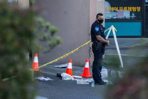 A police officer stands outside of Boohan Oriental Market after a shooting on Tuesday, Sept. 29, 2020 in Everett, Wa. (Olivia Vanni / The Herald)